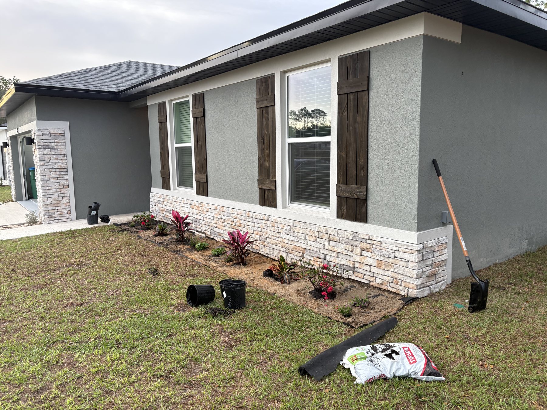 Custom stained shutters and landscape beds by KDP Builders