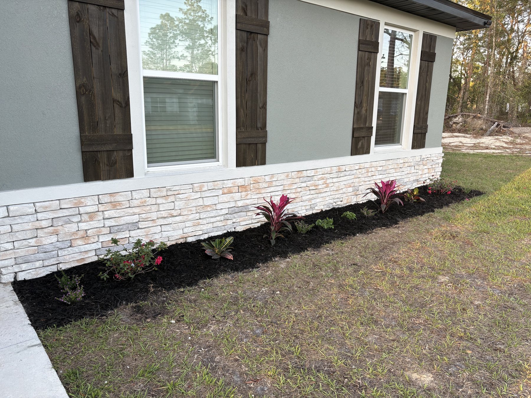 Front landscaping and custom stained shutters by KDP Builders